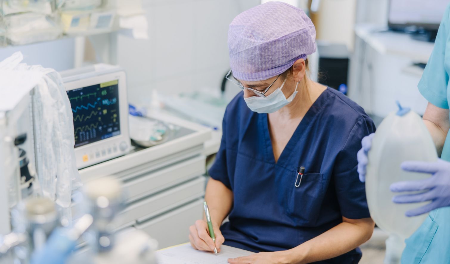 Anästhesieteam dokumentiert Vitalwerte während Narkose, lückenlose Überwachung und Sicherheit im OP